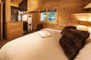 a bedroom with a bed in a wooden cabin at Chalet Bachal in Manigod