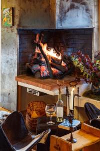 a room with a fireplace and a table with a wine glass at Chalet Bachal in Manigod +24 photos