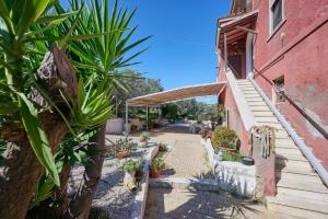 an outdoor pathway with potted plants and a building at La Casa Di Simba A Piombino in Piombino
