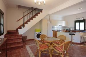 a kitchen with a table and chairs and a staircase at Villa Los Pinos in Marchena