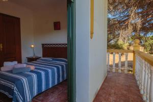 a bedroom with two beds and a balcony at Villa Los Pinos in Marchena +25 photos