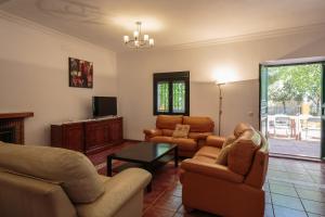 a living room with two couches and a tv at Villa Los Pinos in Marchena