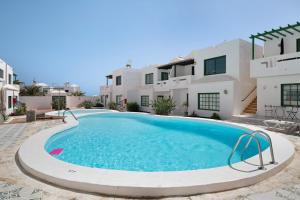 a swimming pool in front of a villa at Noaian in Puerto del Carmen