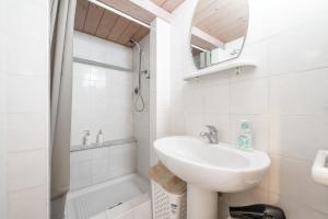 a white bathroom with a sink and a mirror at In casetta in Cagliari +23 photos