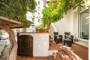 a patio with trees and chairs and a building at In casetta in Cagliari