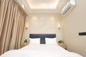 a bedroom with a large bed with white sheets at Town Centers in Ghaziabad