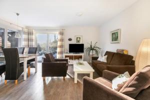 a living room with a couch and a table at Solarferienhaus Wolkenlos in Breklum