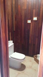 a bathroom with a toilet and a wooden wall at Chalet Rural Marian in Santa Maria de Guia de Gran Canaria