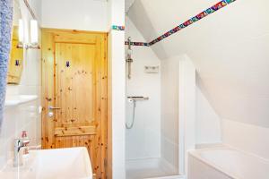 a bathroom with a shower and a wooden door at Friesenwald in Zetel +16 photos