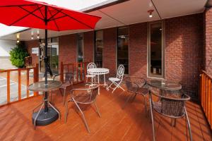 a patio with tables and chairs and an umbrella at Travel Inn Kofu in Kofu