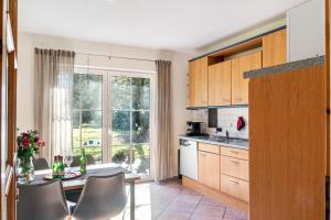 a kitchen with a table and chairs and a window at Friesenwald in Zetel