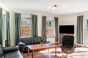 a living room with a couch and chairs and a tv at Friesenwald in Zetel