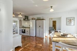 a kitchen with white appliances and a table and chairs at Ca la Yaya in Llança