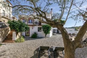 a house with two chairs and a tree at Ca la Yaya in Llança