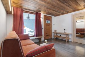 a living room with a couch and a large window at Casa Nadia in Verceia
