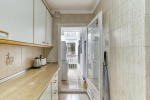 a kitchen with white cabinets and a refrigerator at Roses Sweet Home in Roses