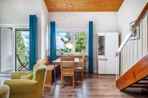 a dining room with blue curtains and a table and chairs at Himmelblau in Schönwald