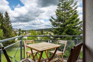 a table and chairs on a balcony with a view at Himmelblau in Schönwald