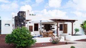 a house with a patio with an umbrella at Casa Margarita 4 in Mala