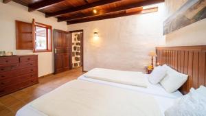 a bedroom with two white beds and a dresser at Casa Margarita 4 in Mala