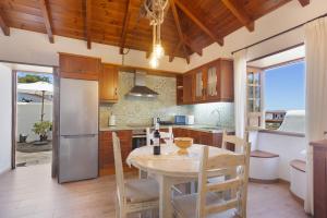 a kitchen with a table and chairs and a refrigerator at Volcán 18 in Tanque