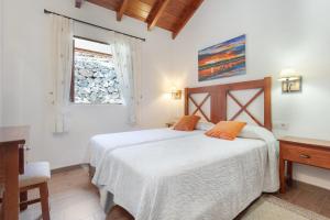 a bedroom with a bed and a desk and a window at Volcán 18 in Tanque