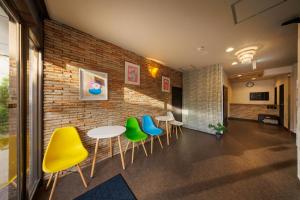 a room with chairs and tables and a brick wall at Travel Inn Kofu in Kofu