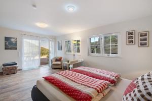 a bedroom with a large bed and windows at Ferienwohnung Weitblick in Sasbachwalden