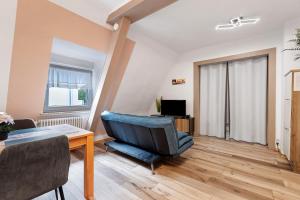 a living room with a table and a blue chair at Casa Doro in Donaueschingen