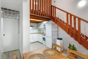 a kitchen with white cabinets and a staircase at Loft Noemi - La Aldea in San Nicolás +13 photos