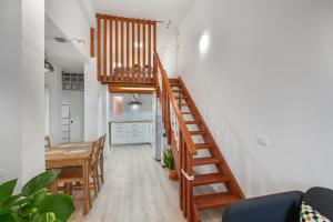 a staircase in a living room with a table and a kitchen at Loft Noemi - La Aldea in San Nicolás