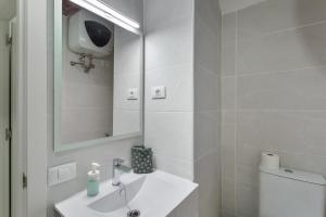 a white bathroom with a sink and a mirror at Loft Noemi - La Aldea in San Nicolás