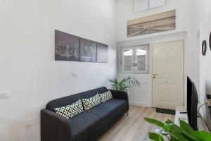 a living room with a black couch and a door at Loft Noemi - La Aldea in San Nicolás
