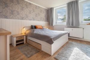 a bedroom with a bed and two windows at Landglück in Hohenmocker