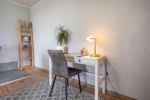 a desk with a lamp and a chair in a room at Landglück in Hohenmocker
