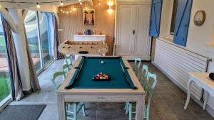 a ping pong table in a room with a pool table at Villa 16 personnes à 50m plage Sud in Lacanau
