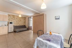 a dining room with a table and a kitchen at Studio tout confort au Ventoux in Malaucène +11 photos