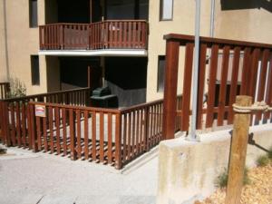a house with a wooden deck with a balcony at Appartement Le Relais Du Devoluy in Le Dévoluy