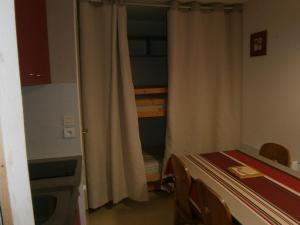 a small room with a table and a kitchen at Appartement Le Relais Du Devoluy in Le Dévoluy