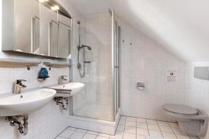 a bathroom with a shower and two sinks and a toilet at Ferienhaus am Mühlenbach, 110qm in Schwanau +22 photos