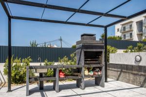 a patio with a pizza oven under a canopy at Apartment Beach Waves Home in Nazaré
