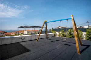 a swing set on the roof of a house at Apartment Beach Waves Home in Nazaré