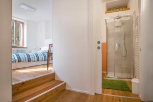 a bathroom with a walk in shower next to a bedroom at Villa Iagra in Tiarno di Sopra +37 photos