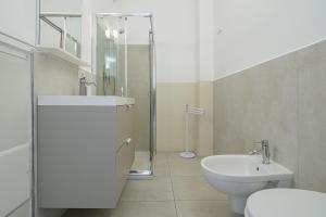 a bathroom with a sink and a toilet and a shower at Cormorani - Appartamento 13 in Golfo Aranci +17 photos