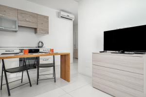 a kitchen with a table and a television on a counter at Cormorani - Appartamento 13 in Golfo Aranci