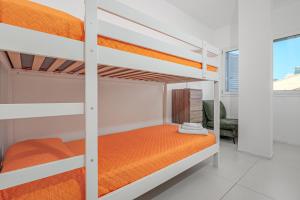a bedroom with two bunk beds with orange sheets at Cormorani - Appartamento 13 in Golfo Aranci