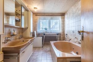 a bathroom with two sinks and a tub at Große Ferienwohnung Wagner in Wehingen +19 photos