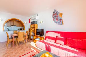a living room with a red couch and a table at 180-degrees sea view with pool in Benitachell