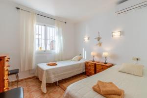a bedroom with two beds and a window at 180-degrees sea view with pool in Benitachell +22 photos