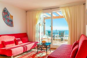 a living room with a red couch and a view of the ocean at 180-degrees sea view with pool in Benitachell